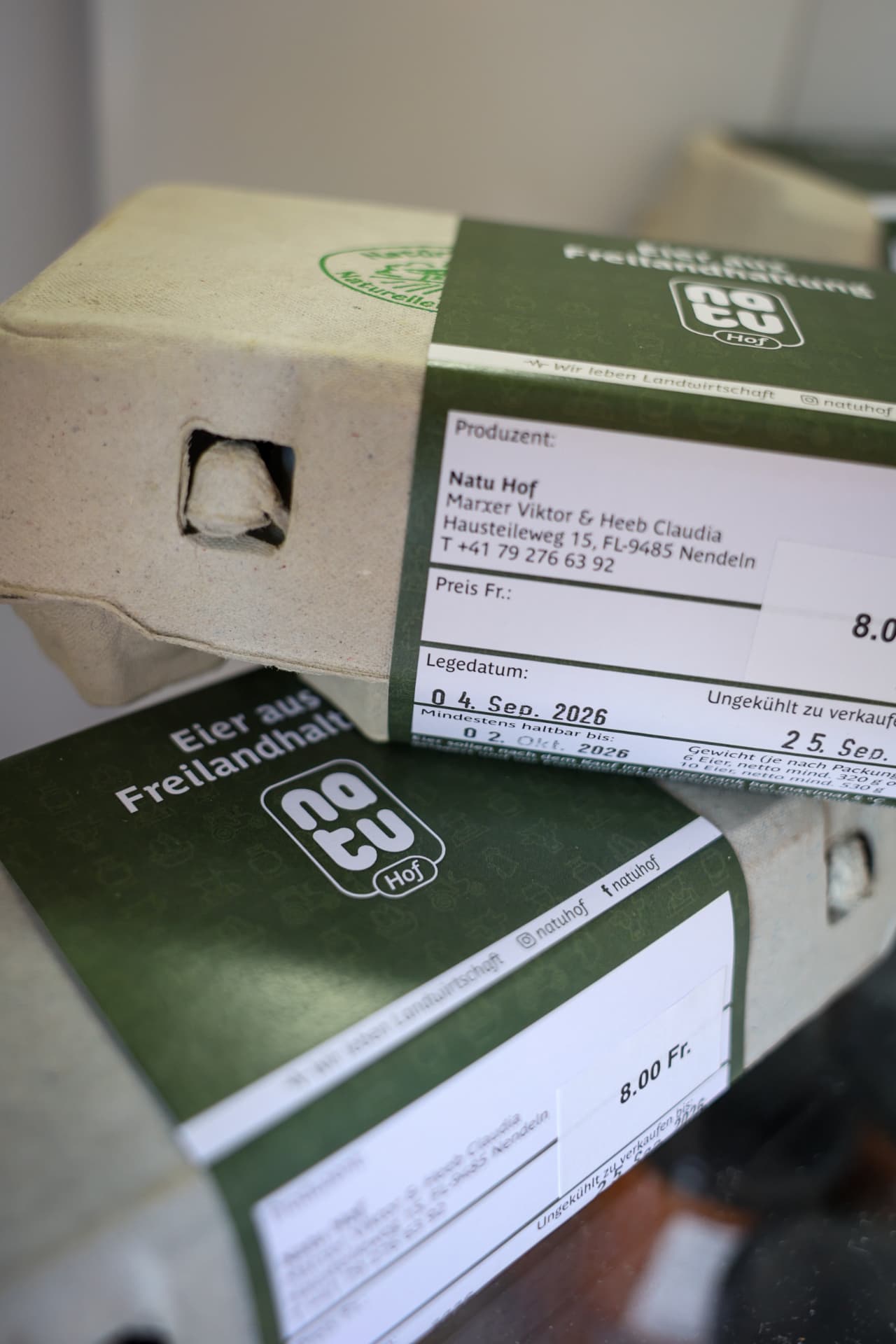 Eierkartons mit grünem Natu-Hof-Etikett Eier aus Freilandhaltung