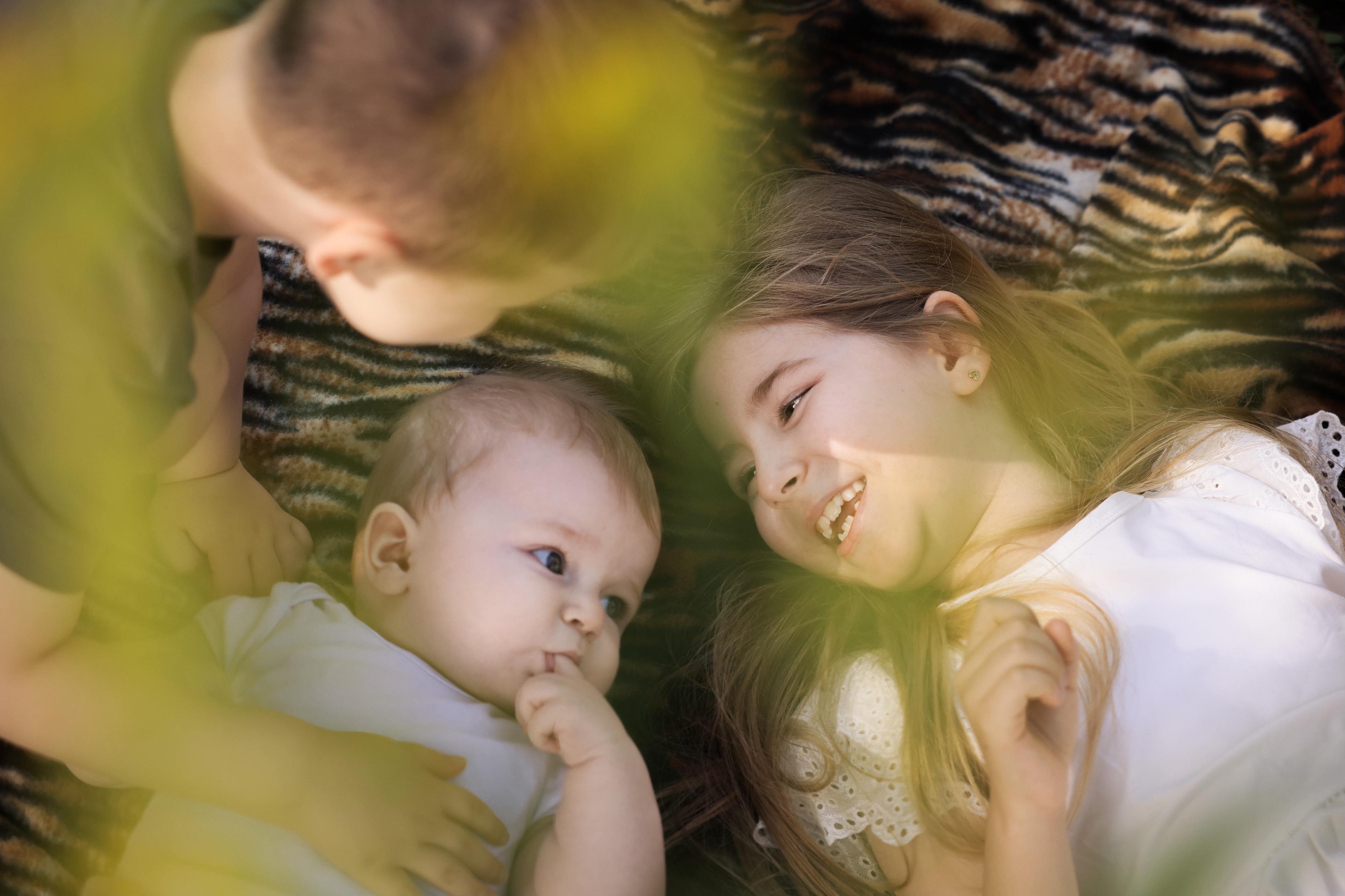 Kinder liegen gemeinsam im warmen Sonnenlicht