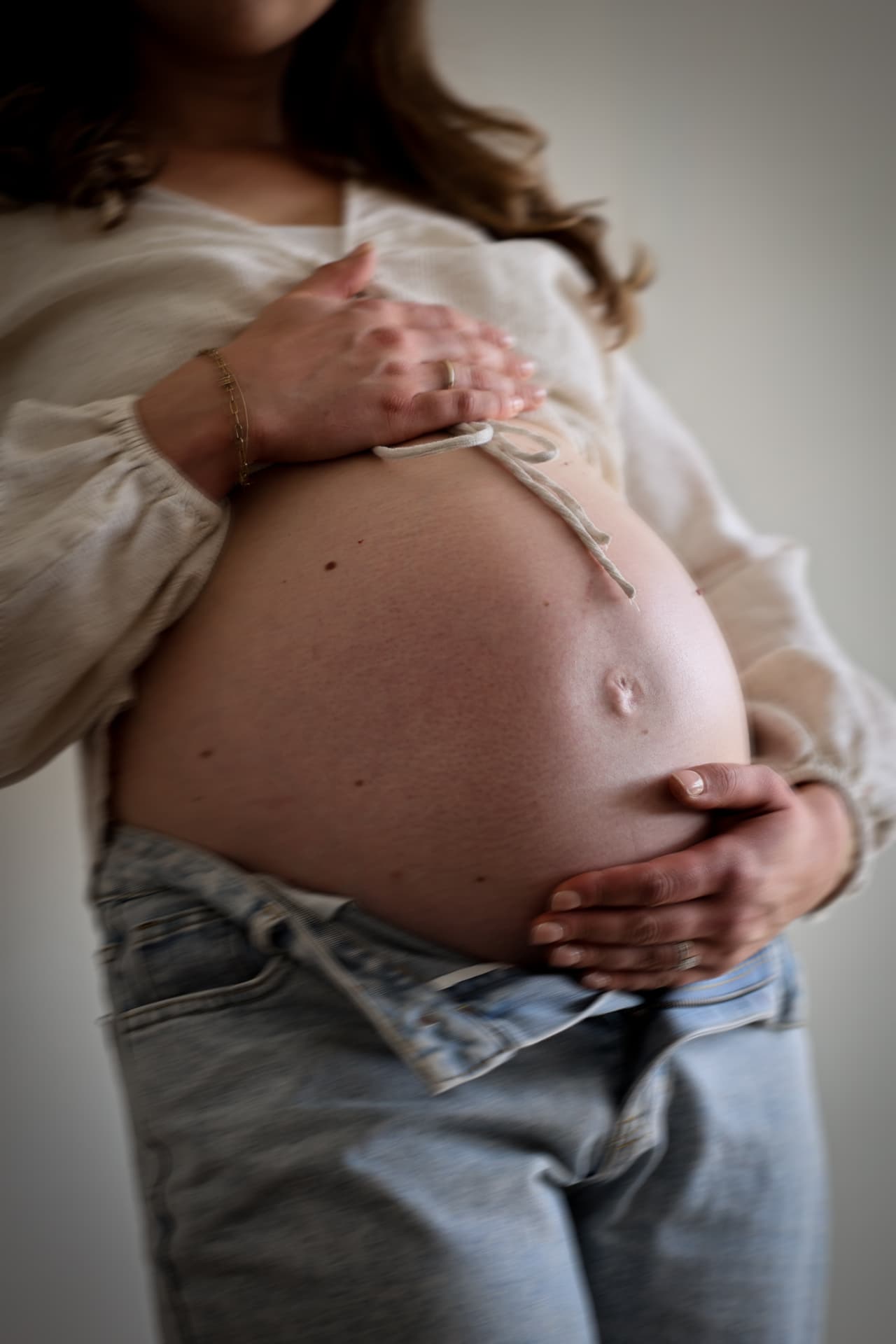 Schwangere hält mit beiden Händen ihren Babybauch